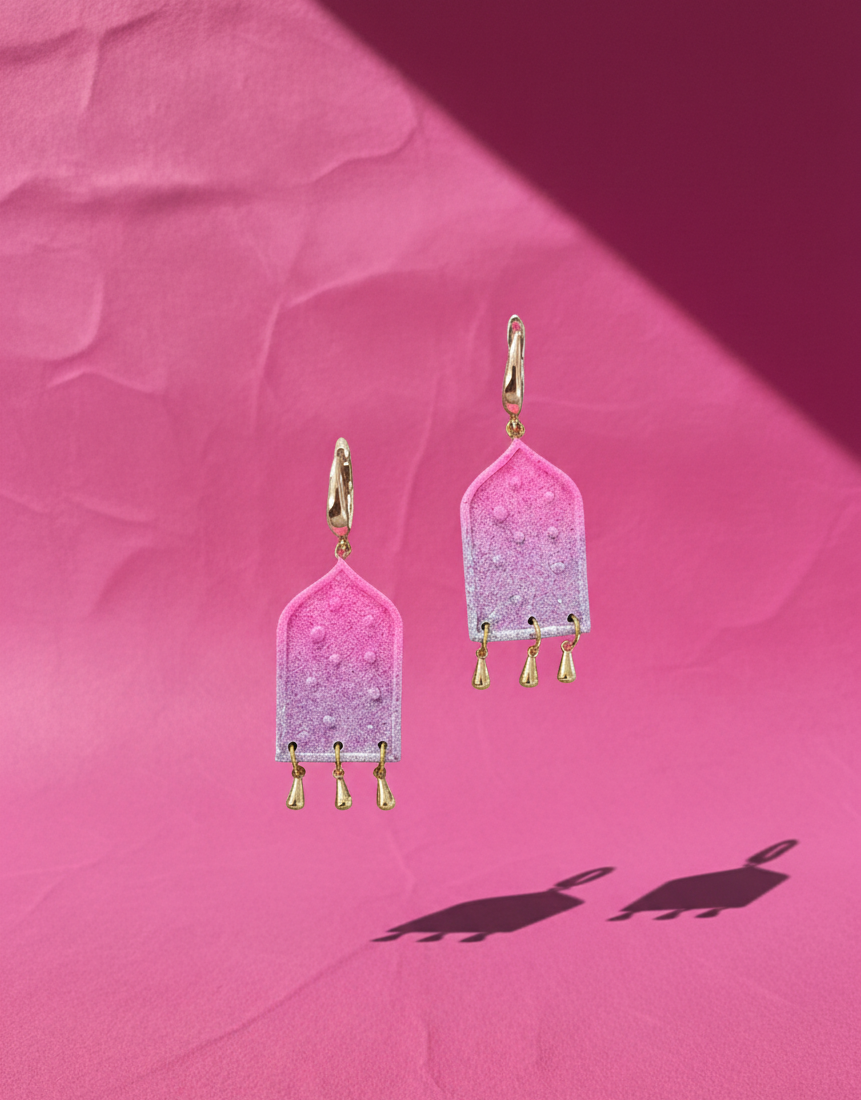 A pair of ombre earrings adorned with tear drop gold plated charms 